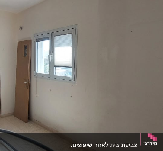 קיר לבן עם סימני צבע, חלון ודלת